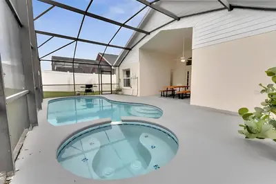 an indoor pool in a house with a glass ceiling at Luxury 4-Bedroom Home with Private Pool, Jacuzzi, AC, Wi-Fi, Cable TV, 5 Minutes from Disney in Kissimmee