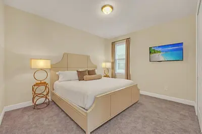 a white bedroom with a bed and a window at Luxe Family Escape at Encore at Reunion in Orlando