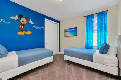 a bedroom with two beds with mickey mouse on the wall at Luxe Family Escape at Encore at Reunion in Orlando
