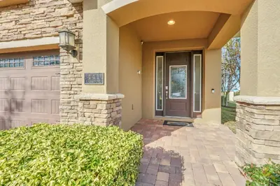 a house with a brown door and a hedge at Luxe Family Escape at Encore at Reunion in Orlando
