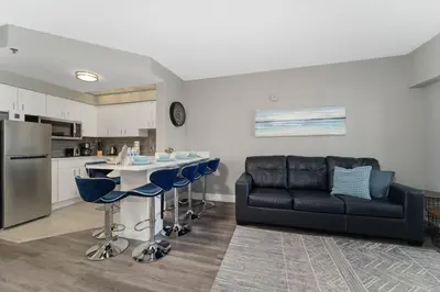 a living room with a black couch and a kitchen at Cozy Orlando Getaway with Pool Access in Orlando
