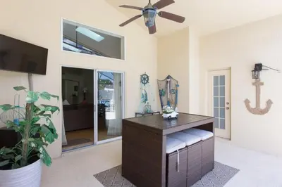 a living room with a table and a ceiling fan at Indian Creek Vacation Home Close to Disney villa in Orlando
