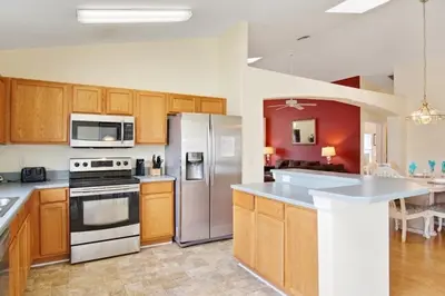 a kitchen with wooden cabinets and stainless steel appliances at Indian Creek Vacation Home Close to Disney villa in Orlando