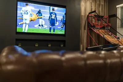 a living room with a couch and a television with a football game at Dream Vacation Home with Lake View, Pool, more, and Walking Distance to Resort in Kissimmee