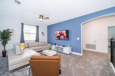 a living room with a white couch and blue walls at 4338JE VILLA 5 BED/5 BA in Kissimmee