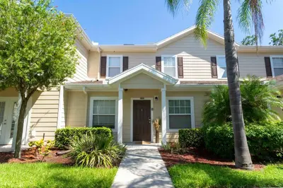 a house with palm trees in front of it at happy place in Kissimmee