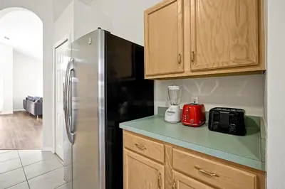 a kitchen with a refrigerator and a blender on a counter at Lake Berkley Home: Pool, Lakefront & near Disney in Kissimmee