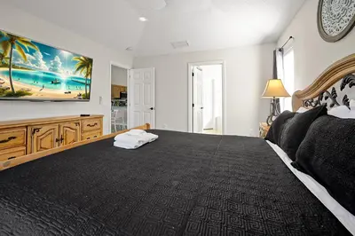 a bedroom with a large bed with a black bedspread at Lake Berkley Home: Pool, Lakefront & near Disney in Kissimmee