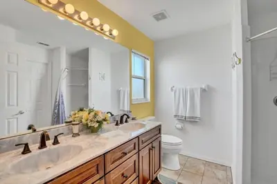 a bathroom with a sink and a toilet and a mirror at 10 Min from Disney Themed 2 Bd Private Pool in Orlando