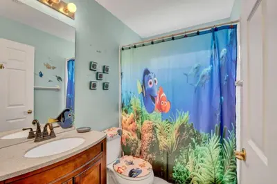 a bathroom with a shower curtain with an aquarium at 10 Min from Disney Themed 2 Bd Private Pool in Orlando