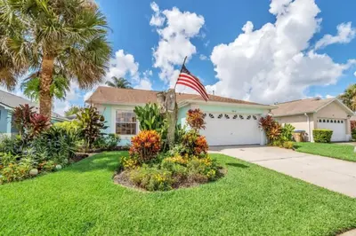 a house with an american flag in the yard at 10 Min from Disney Themed 2 Bd Private Pool in Orlando