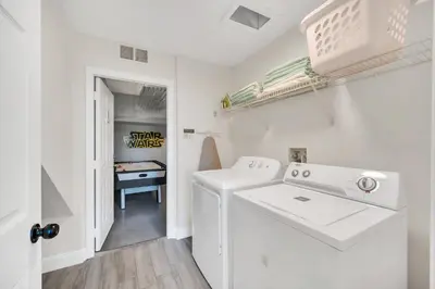 a white laundry room with a washer and dryer at The Ultimate Family Getaway in Kissimmee