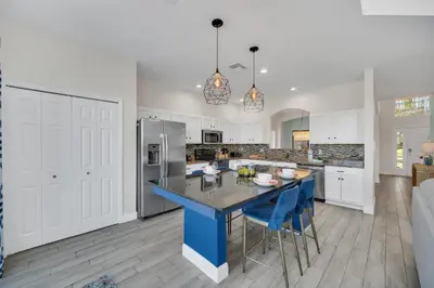 a kitchen with a blue island in the middle at The Ultimate Family Getaway in Kissimmee