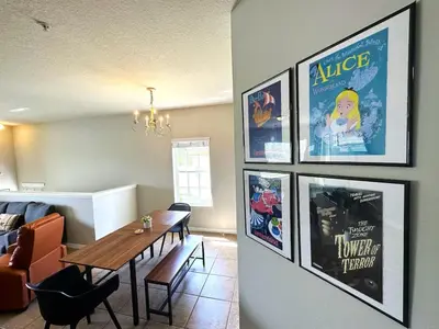 a living room with a table and pictures on the wall at Amazing! Disney 7 Min, Walmart 1 min, 3 Bed 2 bt in Orlando