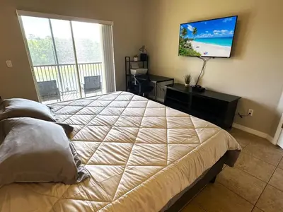 a bedroom with a large bed and a flat screen tv at Amazing! Disney 7 Min, Walmart 1 min, 3 Bed 2 bt in Orlando
