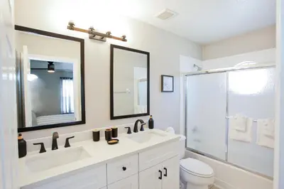 a bathroom with a sink and a toilet and mirror at PN Orlando Vacation Home in Kissimmee
