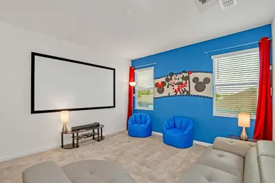 a living room with a couch and a large screen at Home w Pool & Games Room Near Disney -Pet Friendly in Kissimmee