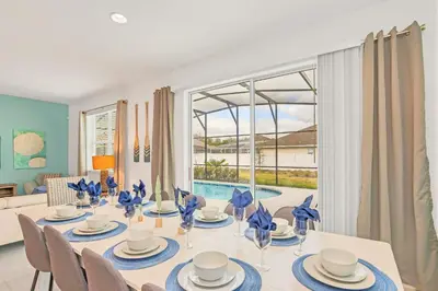 a dining room with a white table and chairs at Home w Pool & Games Room Near Disney -Pet Friendly in Kissimmee