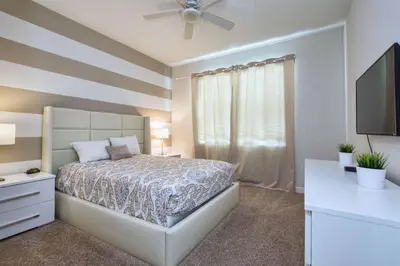 a bedroom with a bed and a dresser and a television at Spacious 6 Bed Home with Pool in Prime Storey Lake Location in Kissimmee