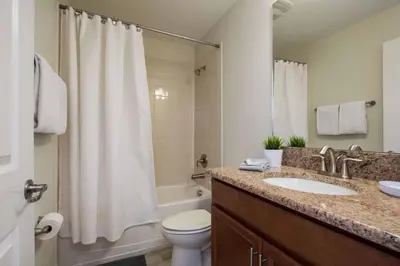 a bathroom with a sink and a toilet and a shower at Spacious 6 Bed Home with Pool in Prime Storey Lake Location in Kissimmee