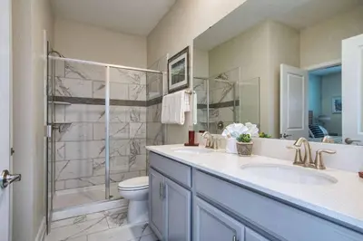 a bathroom with a shower and a sink and a toilet at 9 Bed Home Pool Best Location Storey Lake in Kissimmee