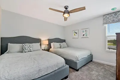 a bedroom with two beds and a ceiling fan at 9 Bed Home Pool Best Location Storey Lake in Kissimmee
