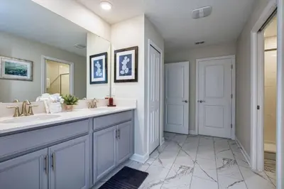 a bathroom with two sinks and a mirror at 9 Bed Home Pool Best Location Storey Lake in Kissimmee