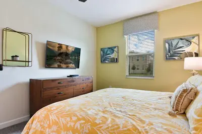 a bedroom with a bed and a dresser and a mirror at 9 Bed Home Themed Rooms Pool Storey Lake in Kissimmee