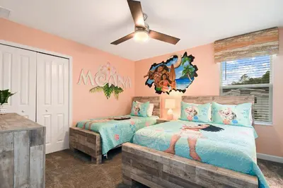 a bedroom with two beds and a ceiling fan at 9 Bed Home Themed Rooms Pool Storey Lake in Kissimmee