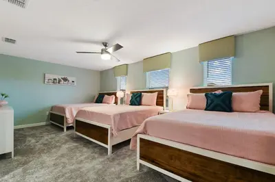 two beds in a room with pink and green walls at 9 Bed Home Themed Rooms Pool Storey Lake in Kissimmee