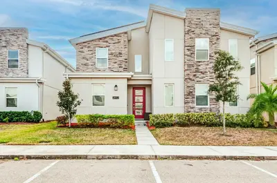 a house with a red door and a sidewalk at 2852 Ultimate Retreat for your family 9 Bedrooms in Kissimmee
