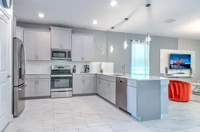 a large kitchen with white cabinets and appliances at 2852 Ultimate Retreat for your family 9 Bedrooms in Kissimmee