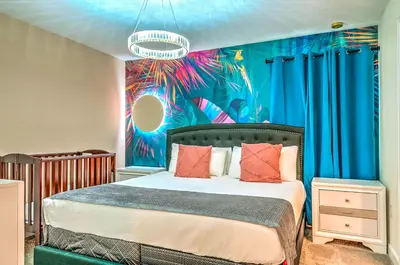 a bedroom with a bed with a painting on the wall at 2852 Ultimate Retreat for your family 9 Bedrooms in Kissimmee