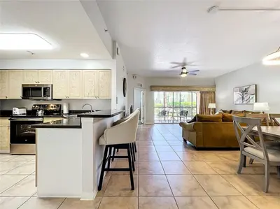 a kitchen and living room with a couch and a table at Spacious 3 Bed 3 Bath Luxury Condo 5 min from Disney in Orlando