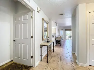 a hallway with a white door and a table at Spacious 3 Bed 3 Bath Luxury Condo 5 min from Disney in Orlando