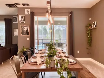 a dining room with a table with plants on it at Luxury 6 Bedroom 5 bath poolHome 214 in Orlando