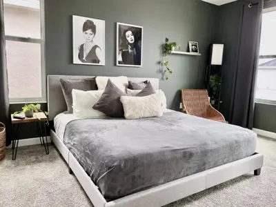 a bedroom with a large bed with gray walls at Luxury 6 Bedroom 5 bath poolHome 214 in Orlando