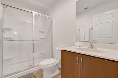 a bathroom with a shower and a toilet and a sink at Upstay Spacious 3BR Home w Resort Access in Kissimmee