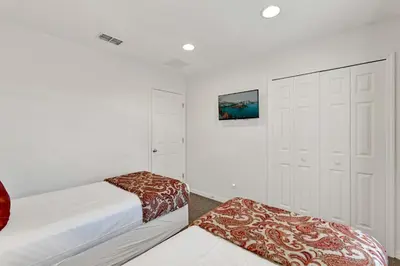 a bedroom with two beds and a closet at Upstay Spacious 3BR Home w Resort Access in Kissimmee
