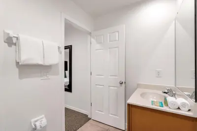 a white bathroom with a sink and a mirror at Upstay Spacious 3BR Home w Resort Access in Kissimmee