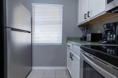a kitchen with white cabinets and a window at Cozy Family 3BR Townhouse Perfect Stay for 6 Guests in Kissimmee