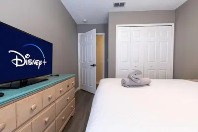 a bedroom with a bed and a flat screen tv at Cozy Family 3BR Townhouse Perfect Stay for 6 Guests in Kissimmee
