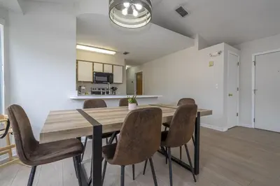 a dining room with a wooden table and chairs at Family Apt very close to Disney in Kissimmee