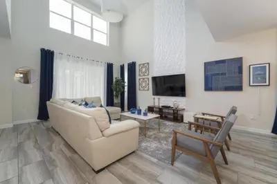 a living room with a couch and a tv at Luxury 5 Bedroom 5 bath private pool Home 279 in Kissimmee