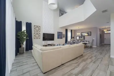a living room with a large couch and a tv at Luxury 5 Bedroom 5 bath private pool Home 279 in Kissimmee
