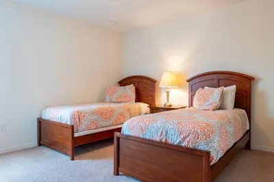 a bedroom with two beds and a lamp on a table at Luxury 4 bedroom 3 bath pool Home 283 in Kissimmee