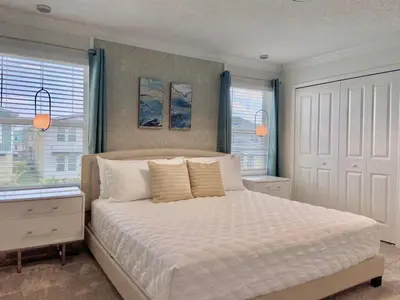 a bedroom with a white bed with two windows at Beautiful 4 bedroom 3 bath pool Townhome 280 in Kissimmee