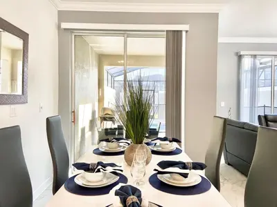 a dining room with a table with chairs and a dining room at Luxury 4 bedroom 3 bath pool Home 264 in Kissimmee