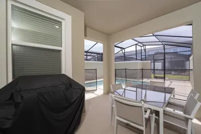 a dining room with a glass table and chairs at Luxury 4 bedroom 3 bath pool Home 271 in Kissimmee