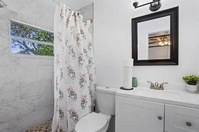 a bathroom with a toilet and a sink and a mirror at APluSS Getaway in Kissimmee